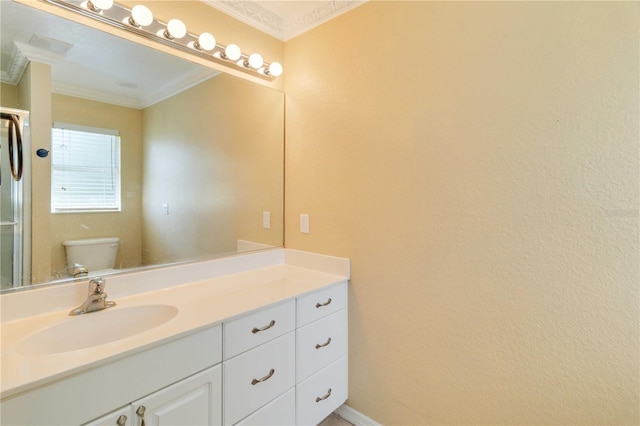 bathroom with ornamental molding, vanity, and toilet