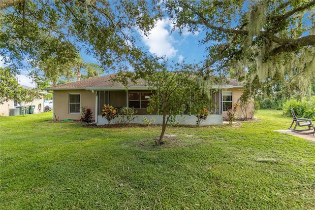 back of property featuring a sunroom and a yard