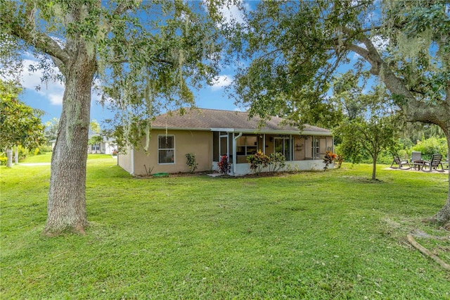 back of house with a sunroom and a yard