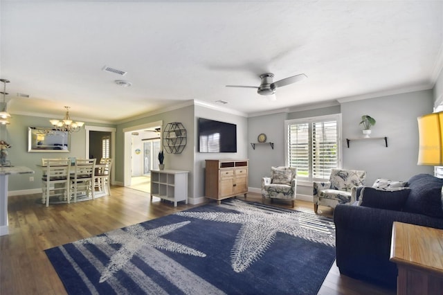 living room with ornamental molding, dark hardwood / wood-style flooring, and ceiling fan with notable chandelier