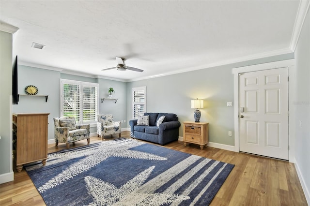 living room with ornamental molding, hardwood / wood-style floors, and ceiling fan