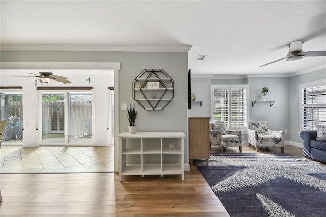 living room with ornamental molding, hardwood / wood-style floors, and ceiling fan