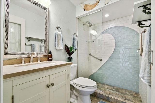 bathroom featuring vanity, a shower with shower door, and toilet