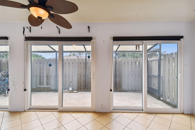 doorway with ceiling fan and light tile patterned floors