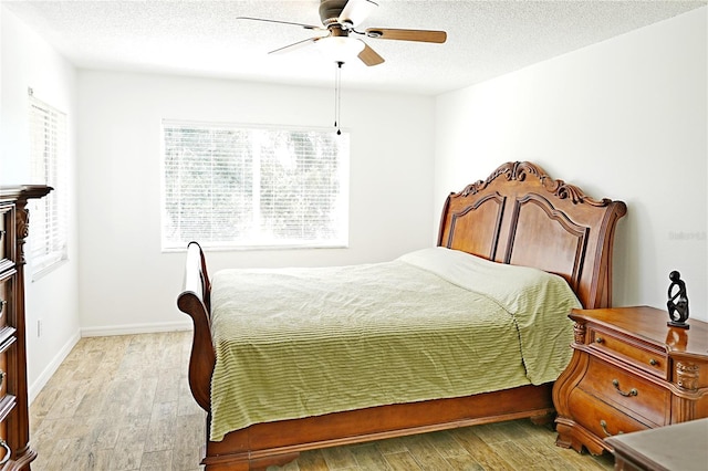 bedroom with light hardwood / wood-style floors, a textured ceiling, and ceiling fan