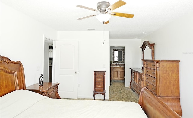 bedroom with connected bathroom, ceiling fan, and a textured ceiling