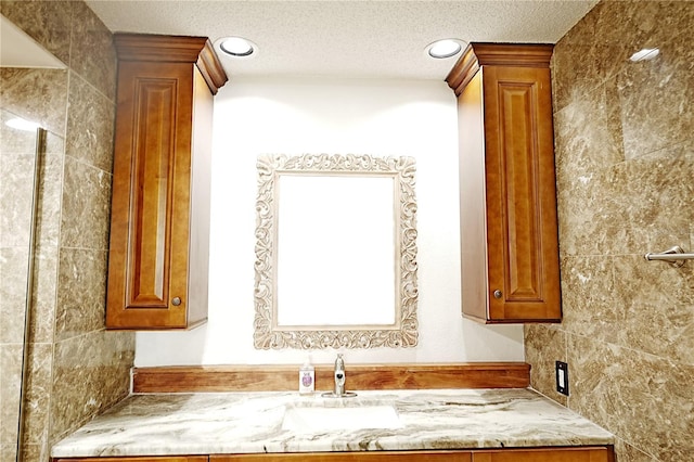 bathroom with vanity, a textured ceiling, and decorative columns