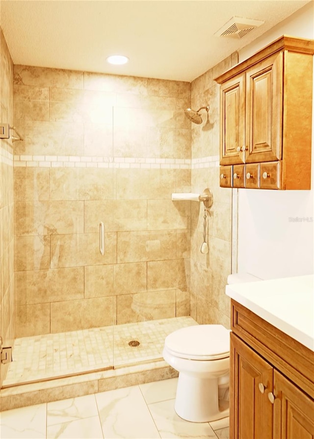 bathroom featuring a shower with door, toilet, and vanity