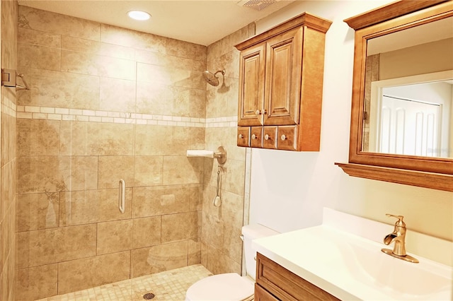 bathroom with vanity, a shower with shower door, and toilet