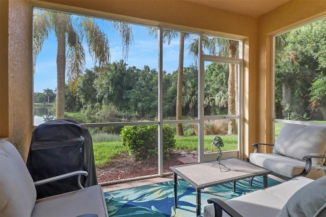 sunroom featuring a water view