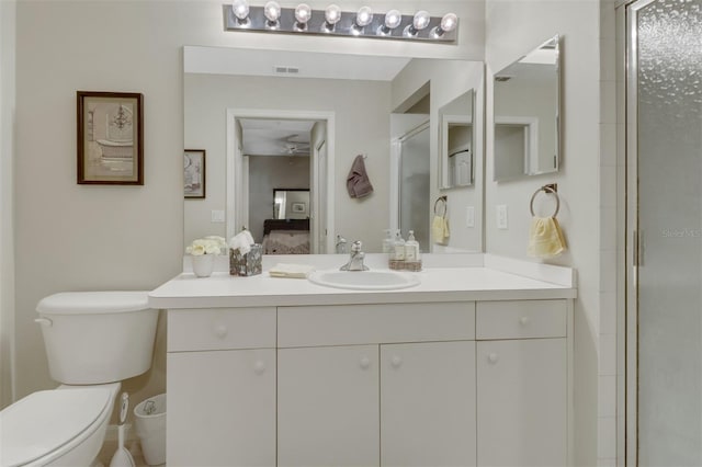 bathroom with vanity, toilet, and a shower with shower door