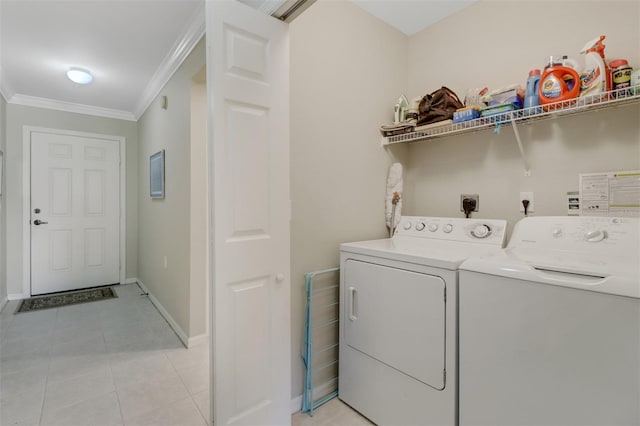 laundry room featuring light tile patterned flooring, washer and clothes dryer, and crown molding