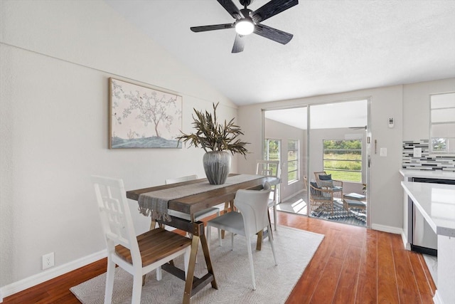 dining space with wood-type flooring, vaulted ceiling, and ceiling fan