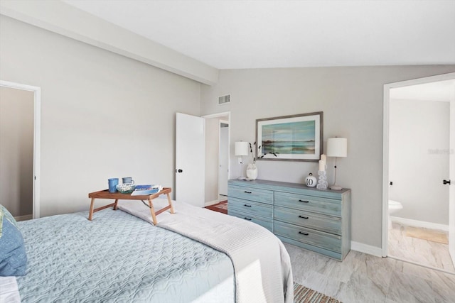 bedroom with ensuite bathroom and vaulted ceiling