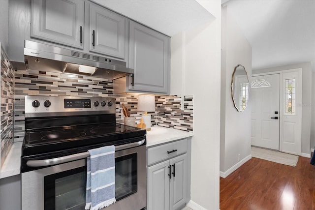 kitchen featuring backsplash, dark hardwood / wood-style floors, electric range, and gray cabinetry