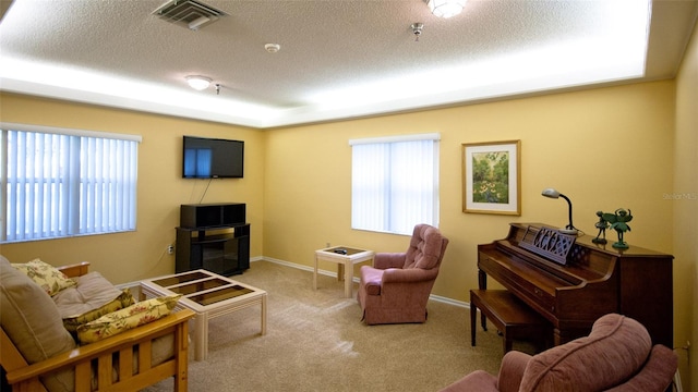 living room featuring a textured ceiling, light colored carpet, and a wealth of natural light