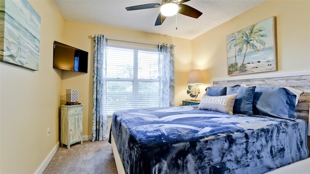 bedroom featuring ceiling fan, carpet floors, and a textured ceiling