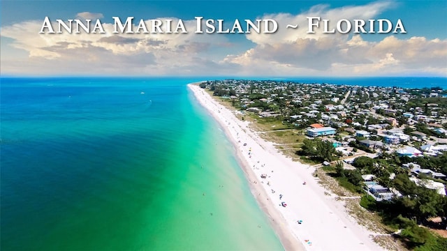 drone / aerial view featuring a water view and a beach view