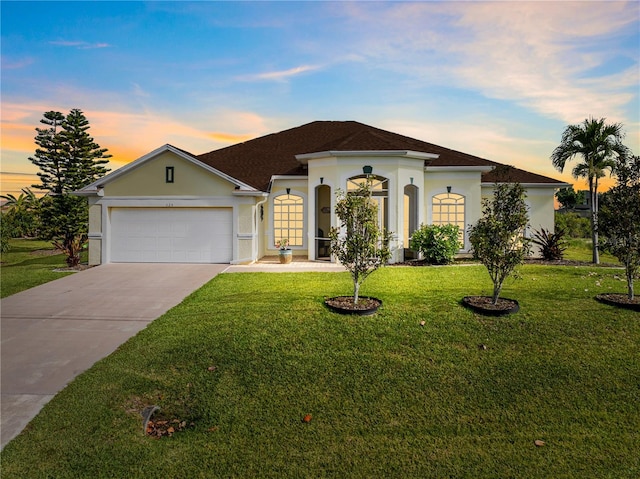 view of front of home featuring a lawn and a garage