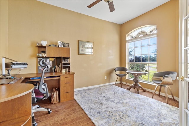 home office with light wood-type flooring and ceiling fan