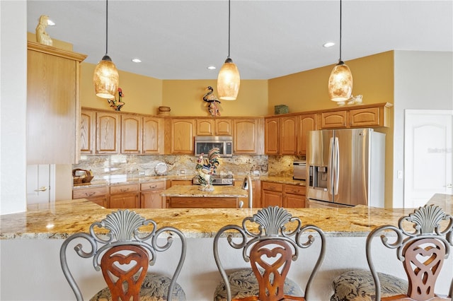 kitchen featuring kitchen peninsula, appliances with stainless steel finishes, and hanging light fixtures