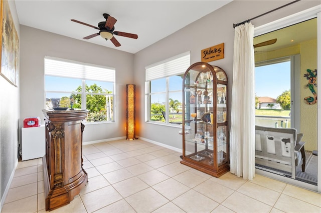 doorway featuring ceiling fan and light tile patterned flooring