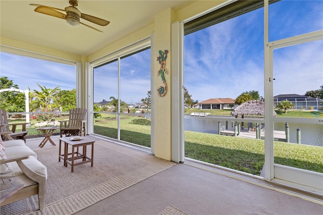 sunroom / solarium with a water view and ceiling fan