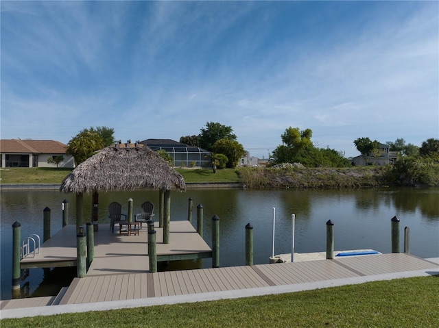 dock area with a lanai, a water view, and a yard