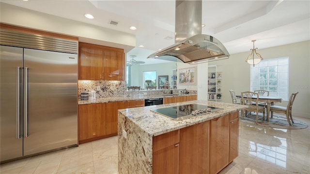 kitchen featuring island exhaust hood, stainless steel built in refrigerator, electric stovetop, a center island, and light stone counters