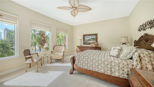 bedroom with multiple windows, light colored carpet, and ceiling fan