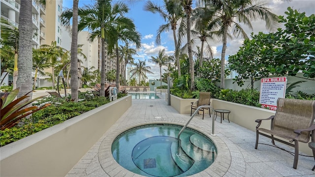 view of swimming pool featuring a community hot tub and a patio area