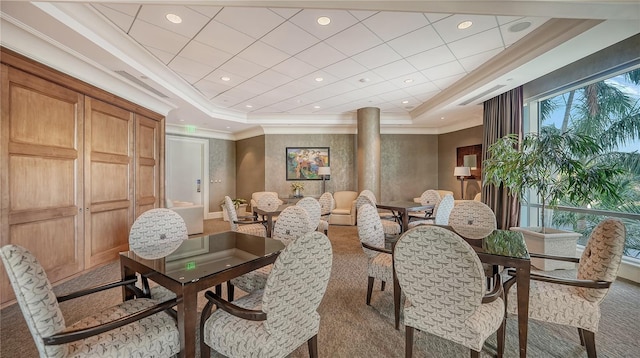 carpeted dining room featuring crown molding and a tray ceiling