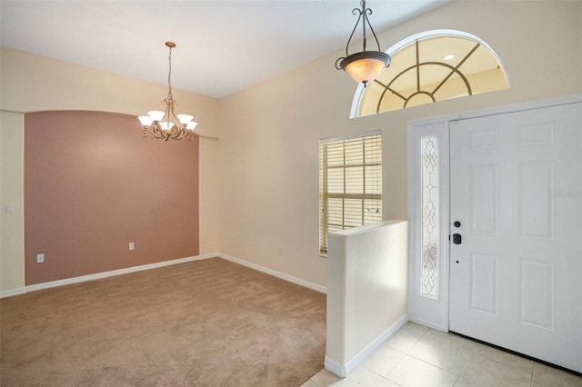 carpeted foyer entrance featuring a chandelier