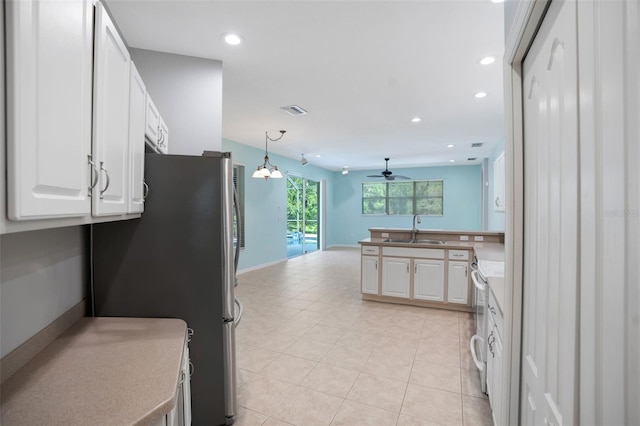 kitchen with white cabinets, pendant lighting, sink, kitchen peninsula, and appliances with stainless steel finishes