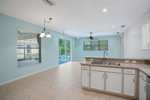 kitchen featuring decorative light fixtures, sink, a healthy amount of sunlight, and white cabinetry