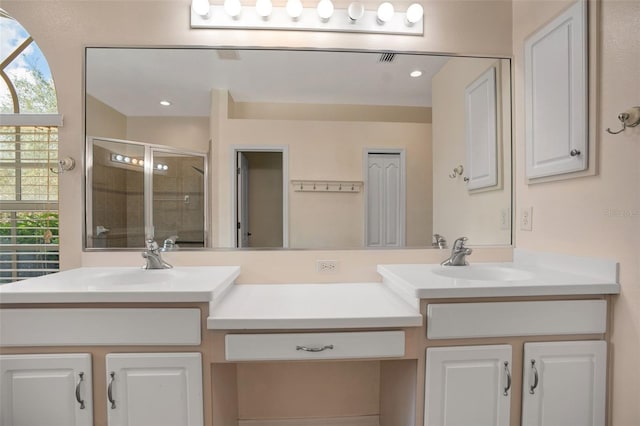 bathroom with a shower with shower door and vanity