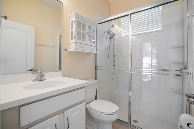 bathroom with walk in shower, vanity, and toilet