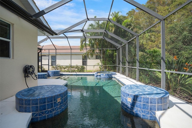 view of swimming pool featuring an in ground hot tub and a lanai