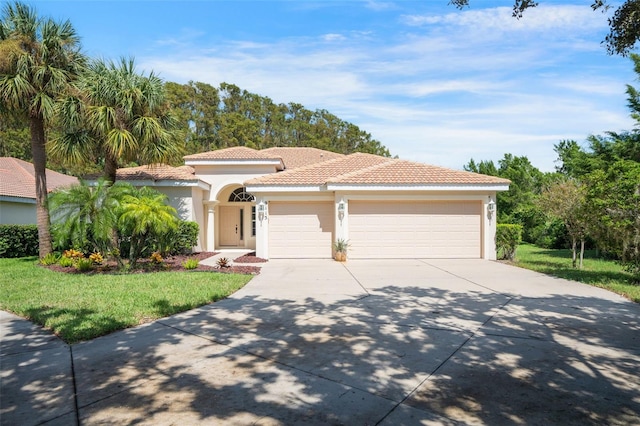 mediterranean / spanish-style house featuring a garage and a front yard