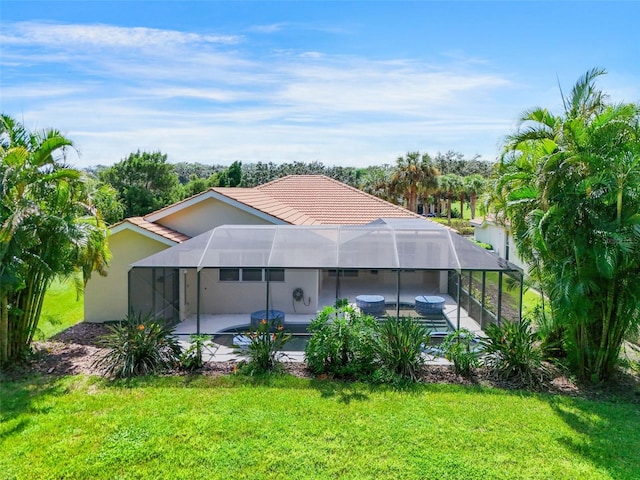 back of house with a patio, a yard, and a lanai