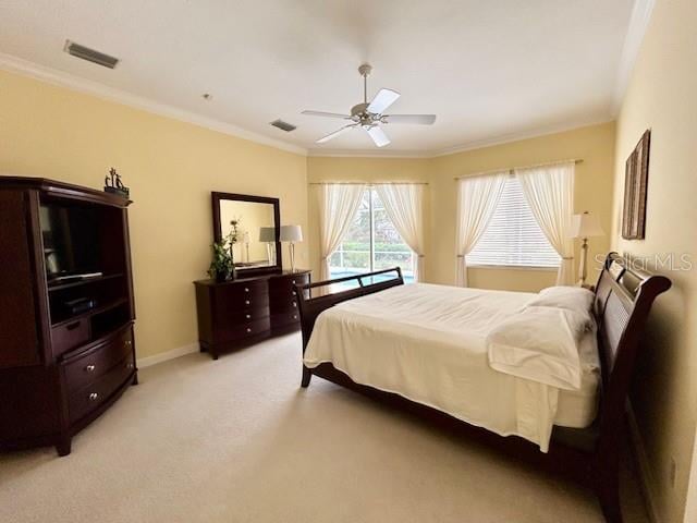 carpeted bedroom with ornamental molding and ceiling fan