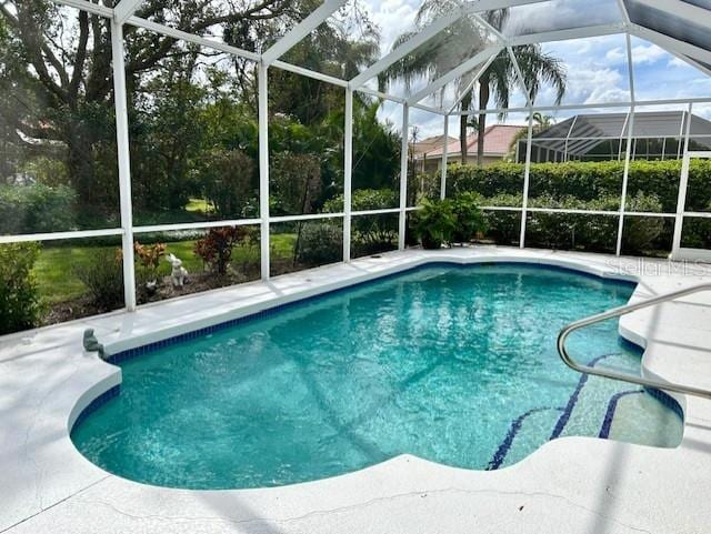 view of swimming pool with a patio and a lanai