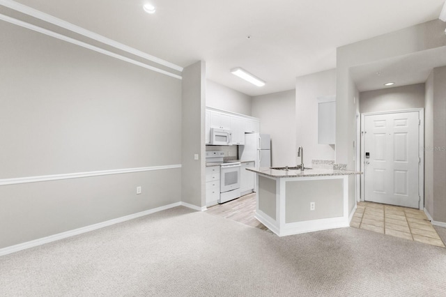 kitchen featuring white appliances, sink, light colored carpet, and white cabinets