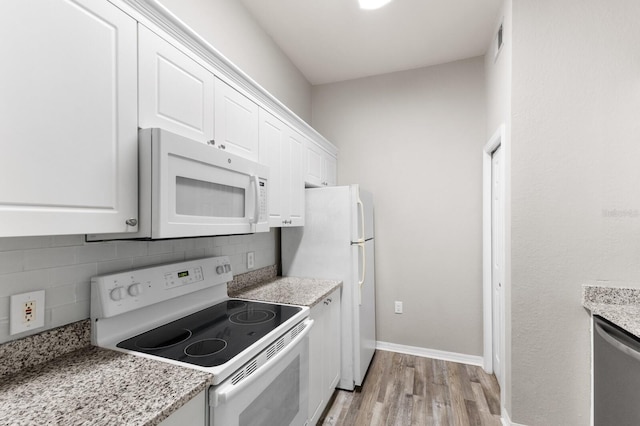 kitchen with white cabinetry, light hardwood / wood-style flooring, decorative backsplash, white appliances, and light stone countertops