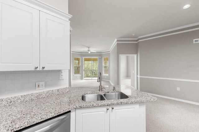 kitchen featuring sink, white cabinets, carpet, ornamental molding, and stainless steel dishwasher