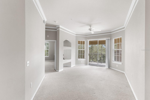 unfurnished living room with ceiling fan, light colored carpet, and crown molding