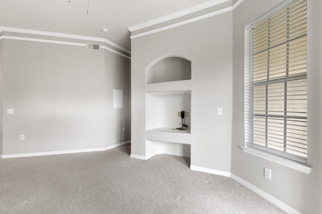 unfurnished bedroom featuring carpet floors, crown molding, and built in desk