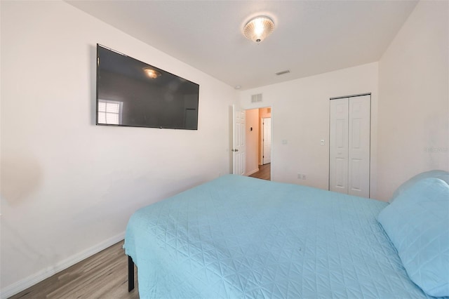 bedroom featuring wood-type flooring and a closet