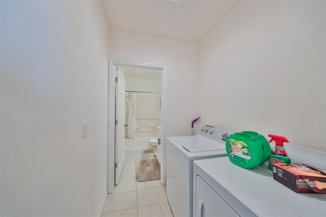 clothes washing area with separate washer and dryer and light tile patterned floors