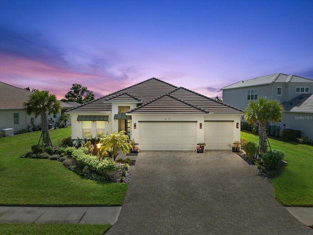 view of front of home with a yard and a garage